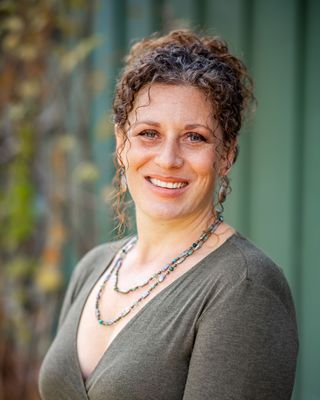 Jessica T Frazier LCSW is a fair skinned woman with light brown wavy hair